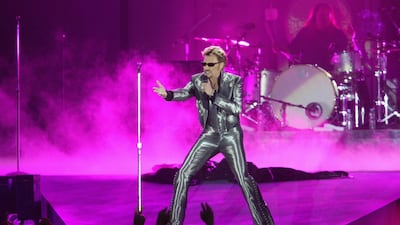 (FILES) This file photo taken on June 11, 2003 shows French singer Johnny Hallyday performing at the Parc des Princes stadium in Paris. France's best-known rock star Johnny Hallyday has died aged 74 after a battle with lung cancer, his wife Laeticia told AFP on December 6, 2017. / AFP PHOTO / FRANCOIS XAVIER MARIT