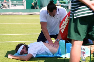Stefanos Tsitsipas receives treatment on his back problem that saw him to retire from his Wimbledon first-round match against French qualifier Valentin Royer. AP