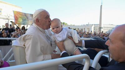 Pope Francis kisses a child during a general audience at the Vatican. Reuters