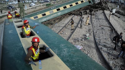 Pakistani security and rescue officials inspect the derailed carriages of a passenger train in Sanghar, near Nawabshah, Pakistan. EPA