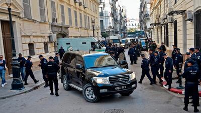 Members of Algerian security stand by upon the arrival of security vehicles transporting the accused to Sidi M’hamed court in the capital Algiers ahead of the opening of a corruption trial of former political and business figures, which has now been postponed. AFP
