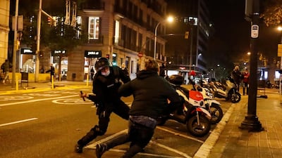A police officer tries to hit a demonstrator with a baton during a protest against the closure of bars and gyms. Reuters
