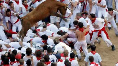 A fighting bull leaps over revelers during festivities in the bull ring on the second day of the San Fermin festival in Pamplona.