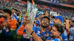 India's Sanju Samson, centre, and Kuldeep Yadav celebrate with the trophy during a victory lap. AFP