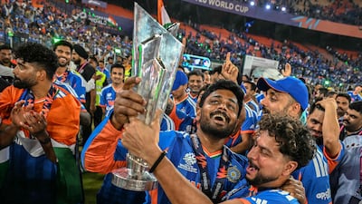 India's Sanju Samson, centre, and Kuldeep Yadav celebrate with the trophy during a victory lap. AFP
