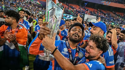 India's Sanju Samson, centre, and Kuldeep Yadav celebrate with the trophy during a victory lap. AFP