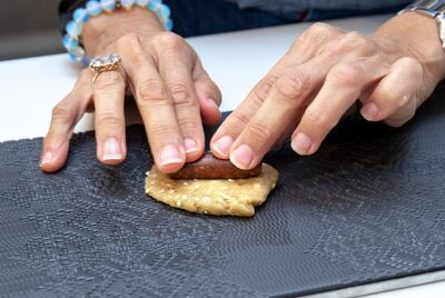 Placing a date log in the centre of the dough. Photo: Victor Besa / The National