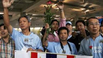 Thai fans of Manchester City club wave the team members on their arrival at the Bangkok airport in November 2007.