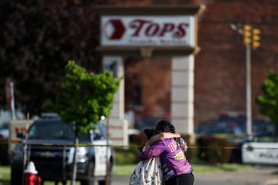 People comfort each other at the scene of the shooting. AP