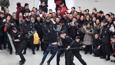 People watch police officers take part in a counter-terrorism exercise at the waiting hall of Changchun railway station as the travel rush for Chinese Lunar New Year, or Spring festival, begins, in Jilin province, China. Reuters