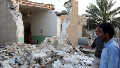 Iranian men stand next to their home after the earthquake. EPA/MOHAMAD FATEMI