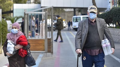 People wearing wearing protective masks walk out of the El-Kettar hospital in the Algerian capital Algiers. AFP