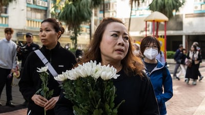 People pay tribute near the scene of the deadly fire. AP