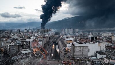 Smoke billows at the site of a collapsed building in Iskenderun, Turkey. Getty