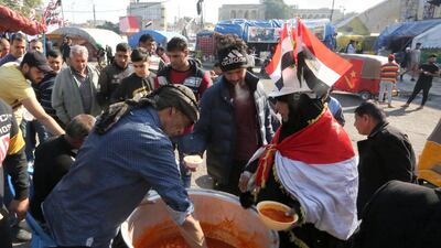 A man serves food to Iraqi protesters gathering at Baghdad's Tahrir Square. AFP
