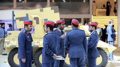 UAE servicemen stand in front of an armoured vehicle at UMEX.