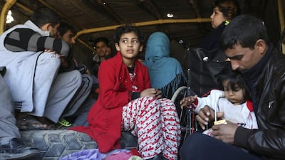 Trapped civilians are loaded in a truck to be taken to safe places as Iraqi security forces clear the Soufiya neighborhood of ISIL fighters on January 14, 2016. Khalid Mohammed/AP Photo