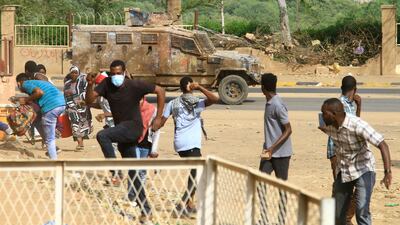 Sudanese anti-coup demonstrators duck for cover as a police vehicle fires tear gas towards them in the capital's twin city of Omdurman on Sunday. AFP