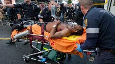 Emergency personnel wheel a shooting victim towards an ambulance for transport to hospital outside the Eaton Centre shopping mall in Toronto.