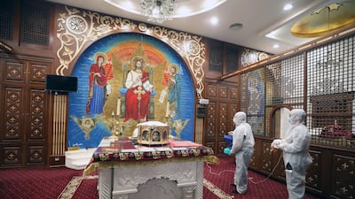 A member of a medical team sprays disinfectant at a church in Cairo. EPA