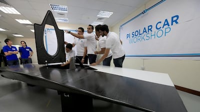 Members of the Petroleum Institute’s solar-powered car core team, from right, Razi ur Rehman, Hamad bin Shaheen, Shihab Solaiman, Khalil Al Hindawi, Yazan Al Hindawi and Asad Saeed inspect the panel of a solar vehicle at their new workshop in the Abu Dhabi institute. Ravindranath K / The National