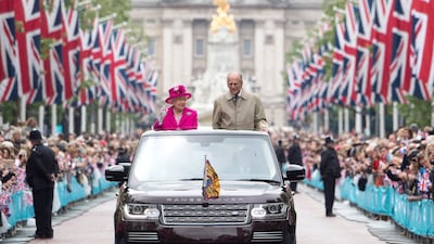 Queen Elizabeth and Prince Philip wave to guests attending "The Patron's Lunch" celebrations for The Queen's 90th birthday on The Mall in June 2016. Getty Images