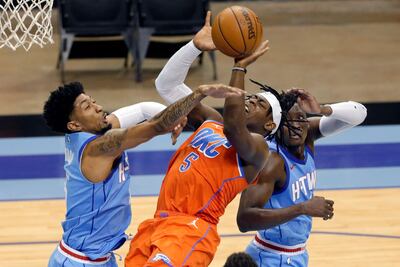 Oklahoma City Thunder forward Luguentz Dort drives up a shot between Houston Rockets center Christian Wood, left, and guard Victor Oladipo. AP
