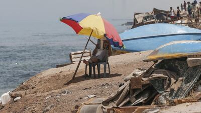 An elderly Palestinian man reads the Koran at the beach of Al-Shati refugee camp in Gaza city, during the last week of the Muslim holy month of Ramadan. AFP