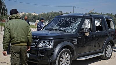 Hamas security officials inspect one of the cars of Palestinian Prime Minister Ramil Hamdallah's convoy that was targeted in an attack after his arrival in Beit Hanun town, the northern Gaza Strip, 13 March 2018.