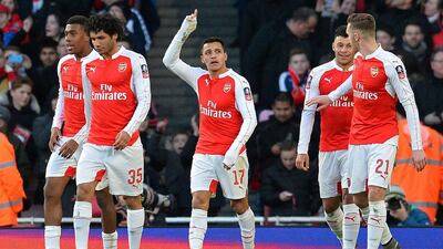 Arsenal's Alexis Sanchez, centre, celebrates scoring his team's winning goal in the second half against Burnley in the FA Cup. Glyn Kirk / AFP
