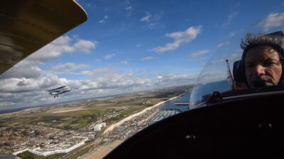 Tiger Moth DH82A, flown over the English coast by pilot Ian Perry, is seen over the shoulder of pilot Pedro Langdon during a promotional event for the upcoming vintage air rally “Crete2Cape” in Brighton, England. The rally will fly across Africa, from Crete to Cape Town, and is only for aircraft built before the December 31, 1939. The journey is expected to take five weeks, with the teams taking to the air on November 13. Leon Neal / Getty Images
