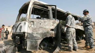 Policemen inspect a burnt bus at the site of a bomb attack in eastern Baghdad.