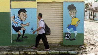 A man walks past caricatures of Argentina's Lionel Messi and Brazil's Neymar in Porto Seguro on June 30, 2014. Arnd Wiegmann / Reuters