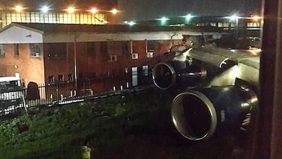 A picture released on Twitter shows the wing of a British Airways plane hitting an office building from a runway at Johannesburg's OR Tambo International Airport. Sean Durkan / AFP