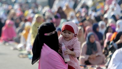 A Filipino mother carries a baby as she attends an Eid Al Adha prayer service in Zamboanga city, southern Philippines. EPA
