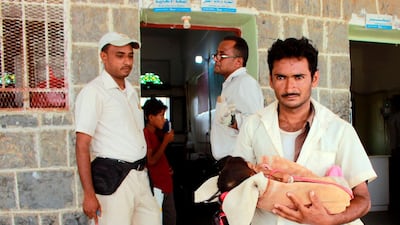 A father holds his malnourished five-year-old daughter outside a treatment centre in Yemen's northern Hajjah province on June 23, 2020. AFP