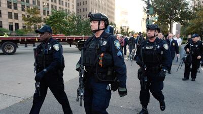 New York Police Department officers gather near the scene after a motorist drove onto a busy bicycle path near the World Trade Center memorial and struck several people Tuesday, Oct. 31, 2017, in New York. (AP Photo/Mark Lennihan)