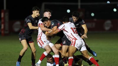 Abu Dhabi Harlequins attempt to tackle a Dubai Exiles player.