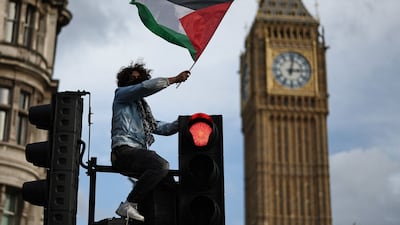 A protester waves a Palestinian flag in London's Parliament Square on Saturday. The UK capital has been the scene of several major pro-Palestinian rallies in this latest round of the conflict. AFP