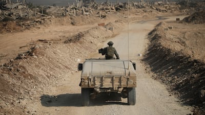 Israeli troops drive past destroyed buildings in the Shujaiya neighbourhood of Gaza city. AP