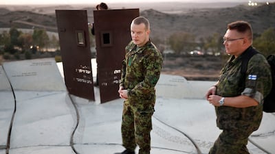 A Finnish military member and an Estonian special forces official look out at the destruction caused by Israel's two-year war on the enclave