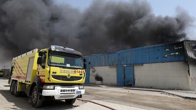 SHARJAH , UNITED ARAB EMIRATES - JUNE 26 : Major fire broke out in the warehouse area in Sharjah Industrial area close to the National Paints in Sharjah. Civil Defense personals trying to control the fire. ( Pawan Singh / The National ) For News. Story by Nawal Al Ramahi