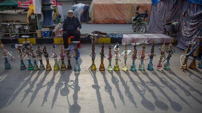 An Iraqi street vendor offers shisha to customers during protests in Tahrir square, Baghdad, Iraq. AP