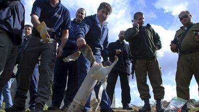 A police officer collects the debris of a rocket that was fired into northern Israel from Lebanon.