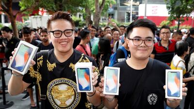 The first customers to buy iPhone X, Kittiwat Wang, 22, and Supakorn Rieksiri, also known as Mod, 22, of Bangkok, pose with their purchases at the Apple store in Singapore. Edgar Su / Reuters