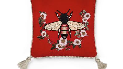 The collection features a variety of cushions, in various shapes and sizes, some with tassels, such as this bee motif example, and others with a border trim. Courtesy Gucci