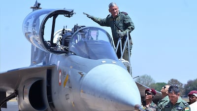 This image taken on February 21, 2019 shows Gen Rawat waving as he gets into the co-pilot seat of a Light Combat Aircraft during the Aero India air show in Bangalore. AFP