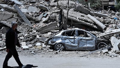 A Syrian man walks by damaged buildings in the town of Douma, the site of a suspected chemical weapons attack, near Damascus, Syria, Monday, April 16, 2018. Two days after Syrian troops declared Douma liberated from opposition fighters, a tour in the city showed the widespread destruction it has suffered since falling under rebel control six years ago. Hassan Ammar / AP Photo
