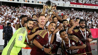 Al Wahda players celebrate with the President's Cup trophy after their victory over Al Nasr in the final on Friday. Pawan Singh / The National