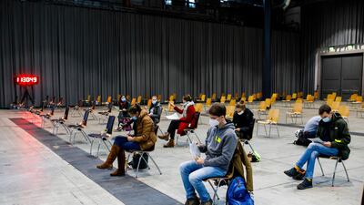 Students sit in a waiting area of the Central Vaccination Centre during a trial run of vaccination against Covid-19, in Freiburg, Germany. AP Photo